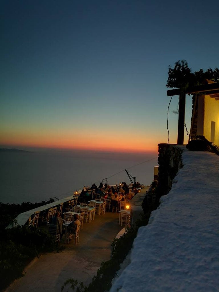 the sunset at 'Manalis Winery' terrace with tourists sitting background with sea